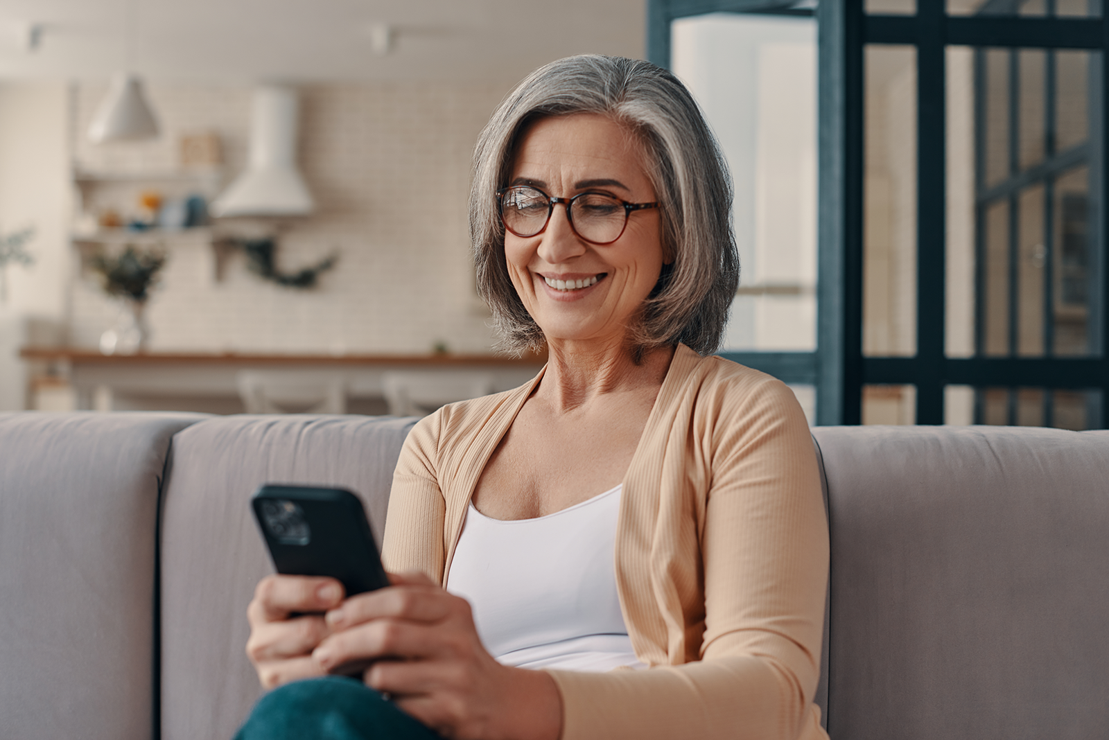 an elderly woman holding her mobile and smiling