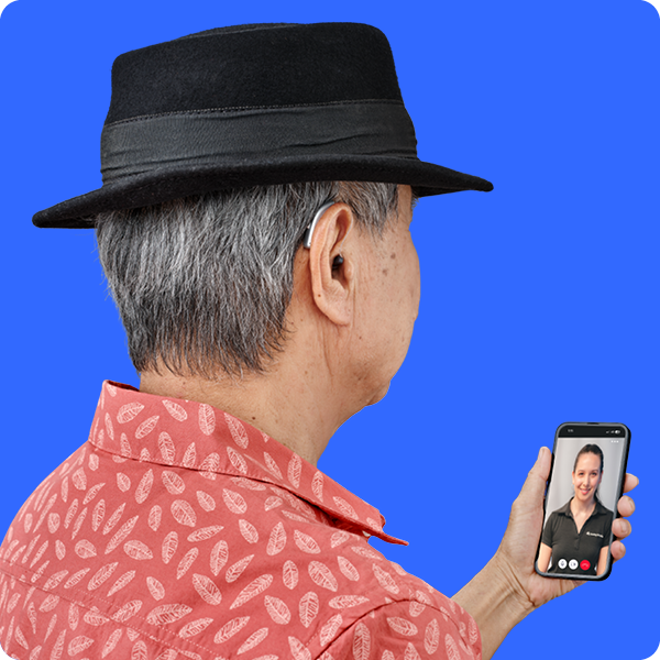 An elderly man using online services through the Hearing Australia app on his phone
